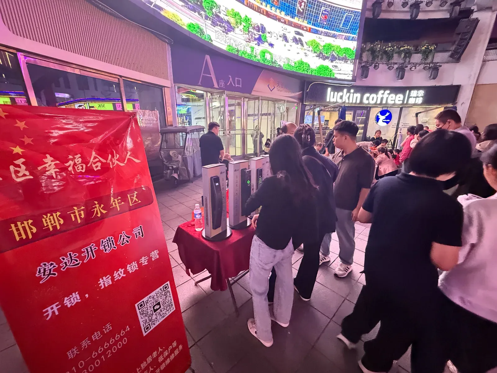 居民在天骏商业广场安达开锁展位了解和体验智能门锁